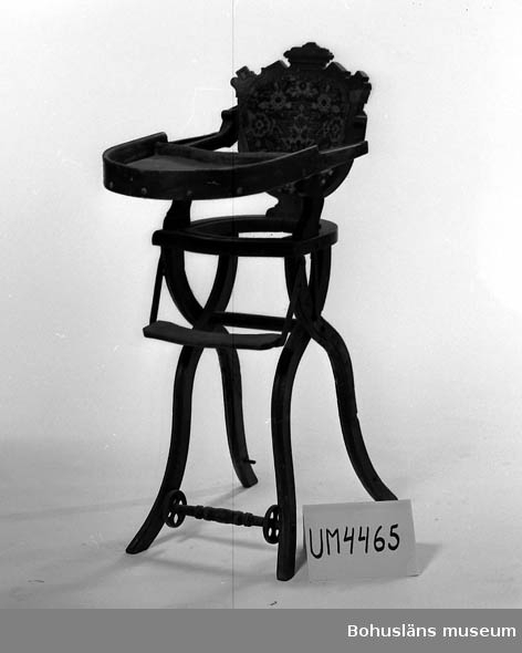 Ur handskrivna katalogen 1957-1958:
Barnstol
H.: c:a 98 cm. Brunt trä. Mönstrad plysch på ryggstödet. Framför sitsen en bricka m. hög kant. Sitsens stoppning o klädsel borta. Nedfällbar, fyra hjul (2 saknas). Illa medfaren.

Lappkatalog: 82