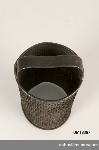 Cylinderformat rivjärn med två olika grovlekar på rivhålen.