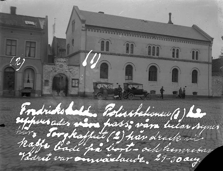 Enligt text på fotot: "Fredrikshald. Polisstationenen (1), här uppvisades våra pass: våra bilar synes här. Torgkafeet (2), här drack vi kaffe både på bort- och hemresan. Vädret var omväxlande. 29-30 aug".
Enligt notering: "Fredrikshalds polisstation 29-30 aug. 1921".