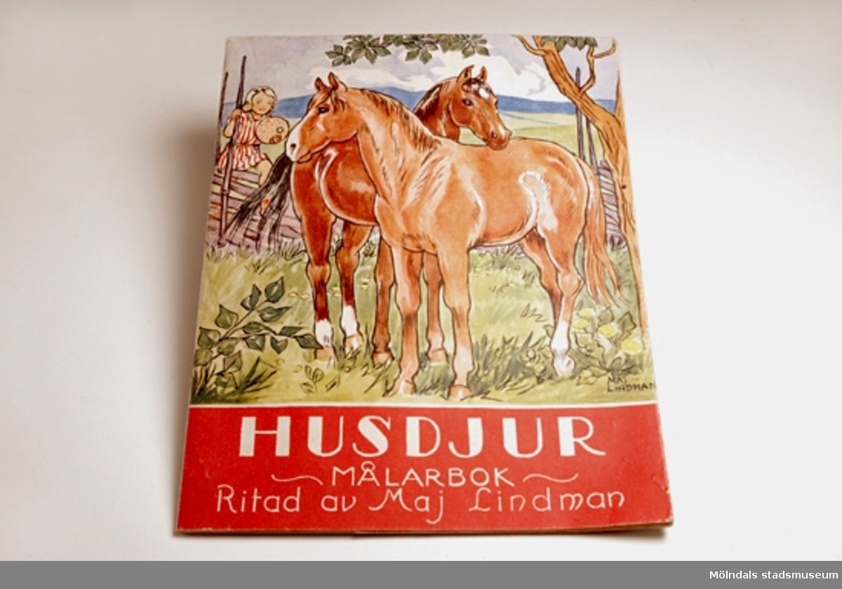 "Husdjur" - Målarbok för barn av Maj Lindman utgiven av AB Lindqvists förlag. På pärmarnas insidor finns samtliga bilder i boken färdigmålade som förlagor. Man kunde vika ut den färdiga bilden, så att den hamnade bredvid den omålade och på så sätt färglägga denna likadant som den redan målade.På framsidan finns en bild av två hästar och en flicka.Brukaren/givaren fick boken som 5-åring och har färglagt bilderna precis som förlagan.