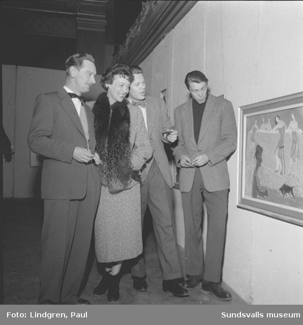 Kvinna och tre män betraktar konst, tavla.