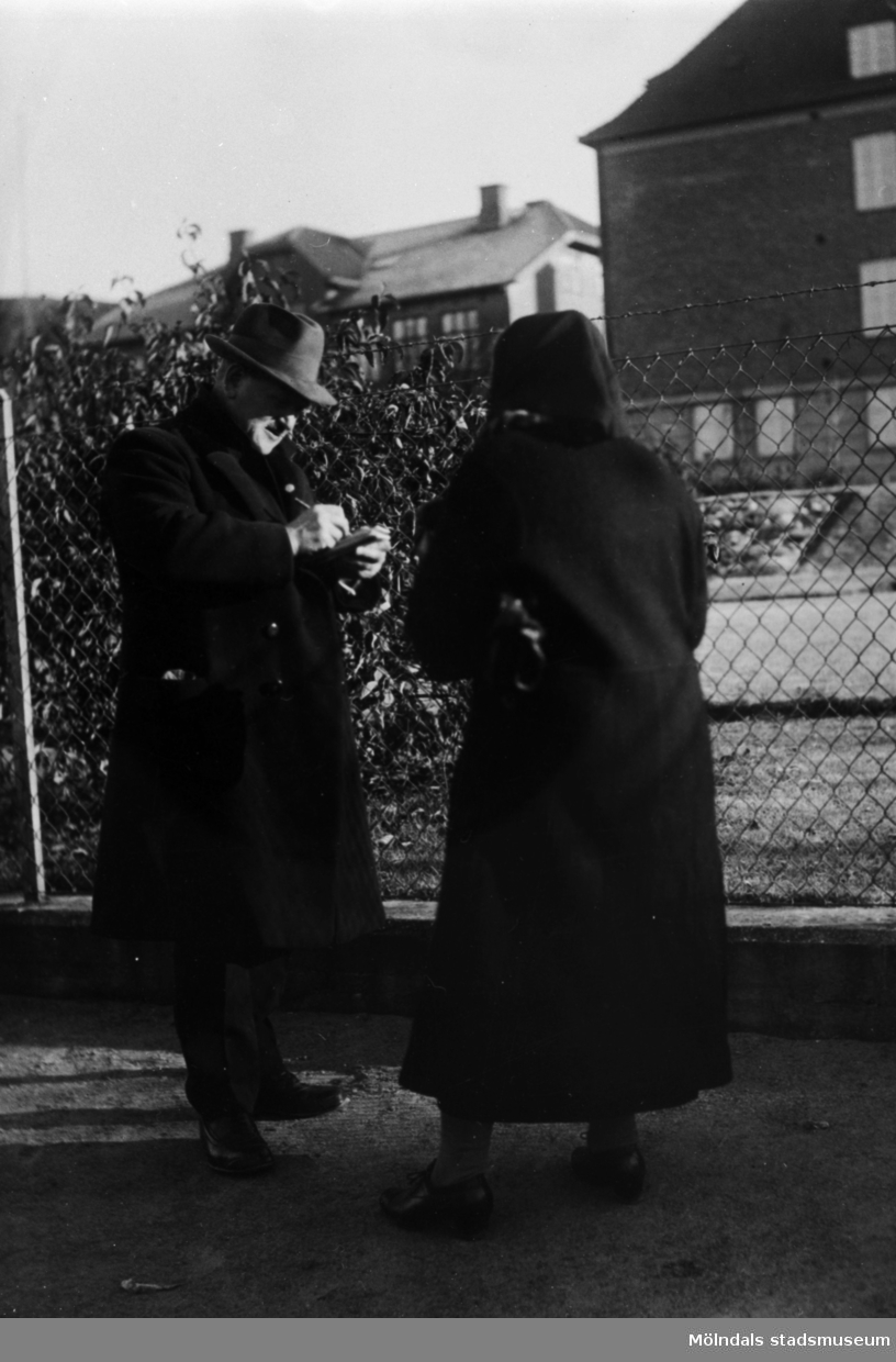 Gustav Svensson var med i kommunfullmäktige samt agent för olika affärer. Han lämnade kredit till folk. På bilden skriver han ut en kredit till en kvinna. Järnvägsgatan i Mölndal år 1931.