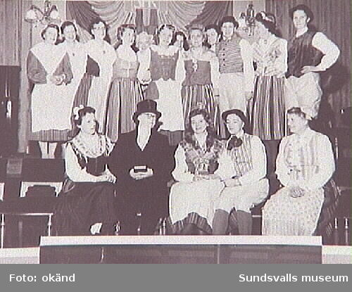 Medlemmar i Sundsvalls Martha-förening framför teaterspel i Stadshuset, 1959. Sittande i mitten Alma Carlsson (som präst), Aina Nilsson, Elna Andersson.