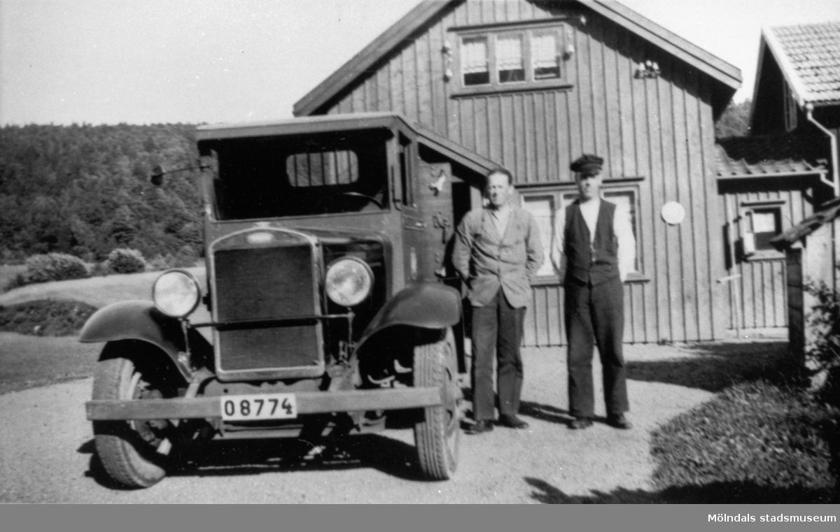 På 1920-talet bytte Anderstorps fabriker ut hästtransporterna  mot biltransport. Här står chaufför Robert Börjesson vid den första bilen. Bredvid står lasthjälpare Erik Göransson.
