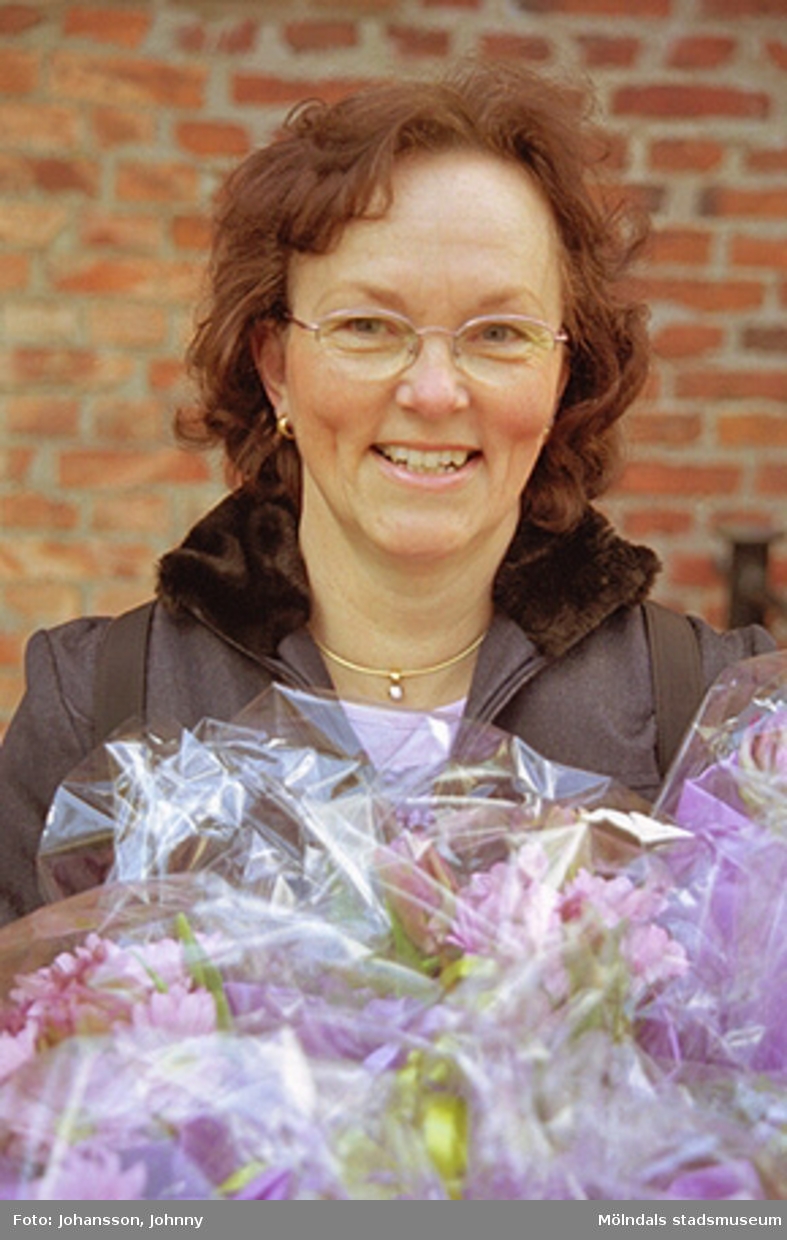 Kvarnbydagen 28 april 2002. Kultursekreterare Gudrun Piculell står beredd att dela ut blommor till dansarna av ForsAnde. I bakgrunden ses Stora Götafors.