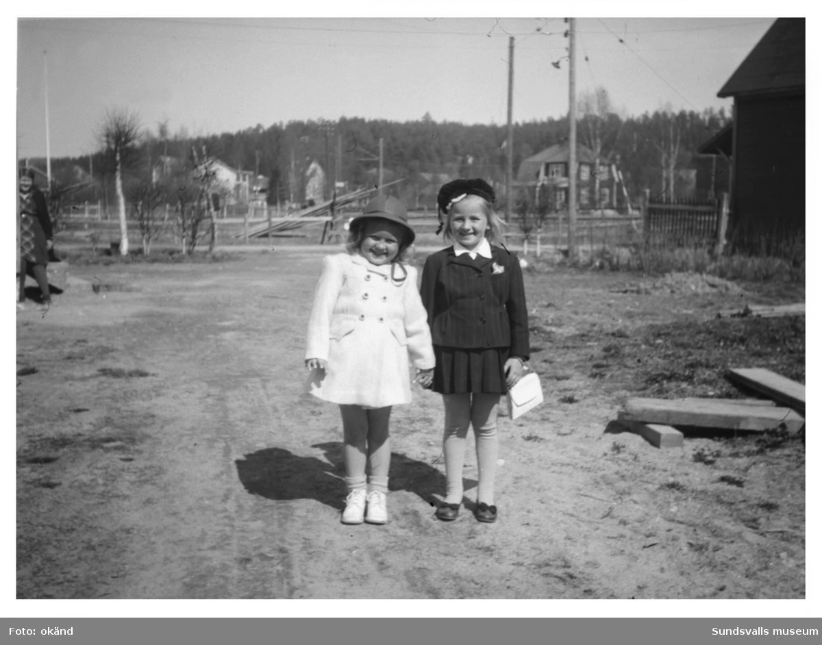 Vårklädda kusinerna Viveca Söderström i vit kappa och röd hatt och Margareta Lindqvist klädd i marinblå dräkt och blå sammetsmössa. Längre fram
på sommaren var högra delen av fotot ett prunkande jordgubbsland