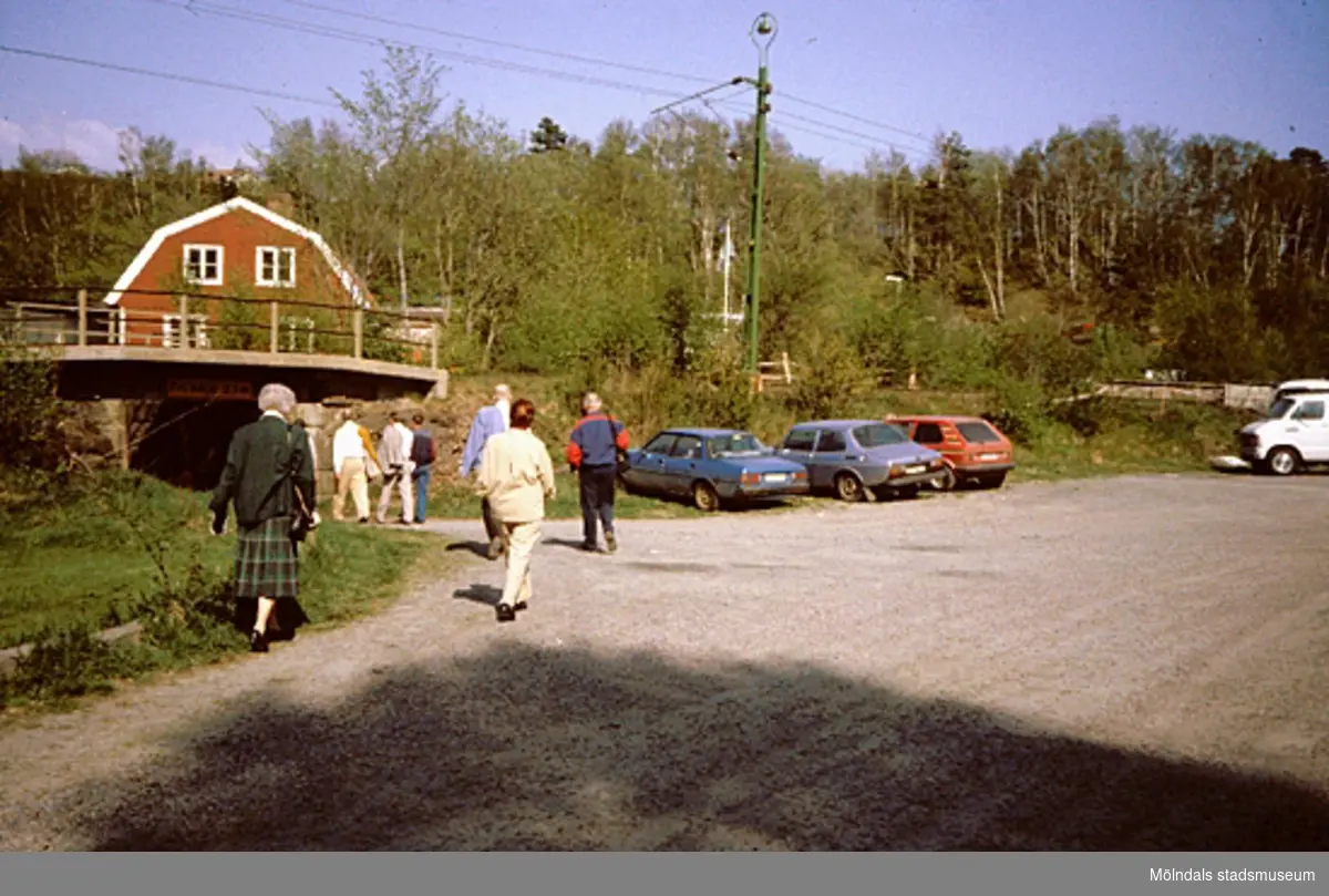 En grusparkering (Stensjön 1:64) vid Boråsbanans järnvägsbro. Samrådsgruppen promenerar i "Övre Kvarnbyn" (Bettyholm mm) 1994-05-09.
