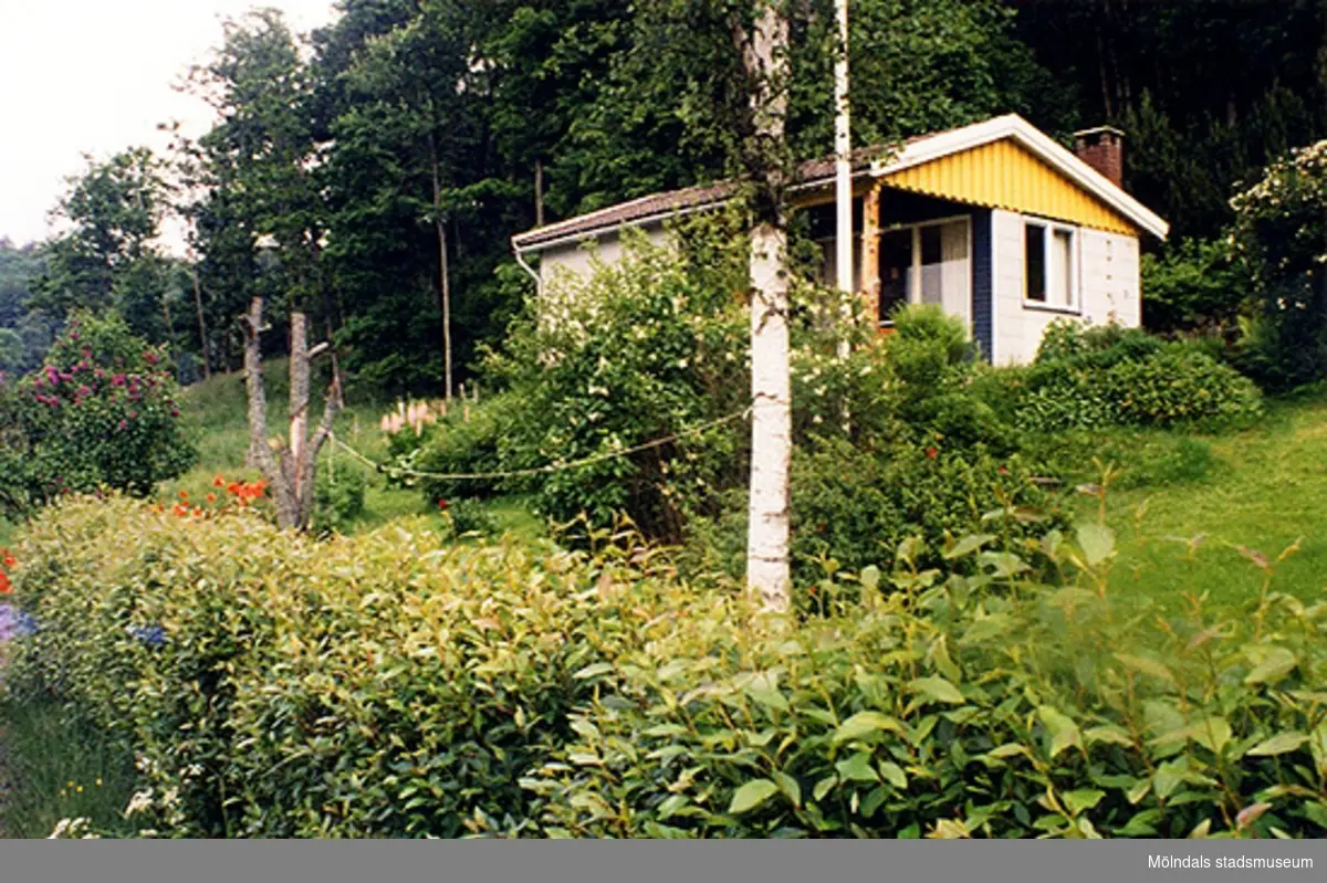 Ett bostadshus på Spårhagavägen (nu: Stamåsvägen 12), Hällesås 1:66, Gastorp i Lindome 1999-06-24. Det hänger en tvättlina mellan träden i trädgården. Relaterat motiv: 2004_1185.