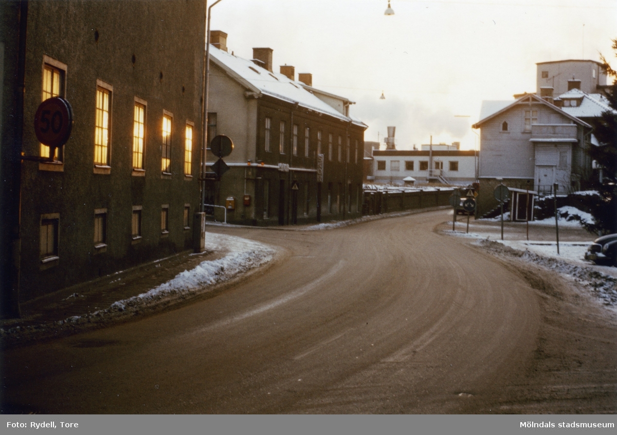Kvarnbygatan vid Gamla Torget i Mölndals Kvarnby på 1970-talet. Vy mot väster. Till vänster ses nr 6 och 4, till höger gaveln på nr 37.