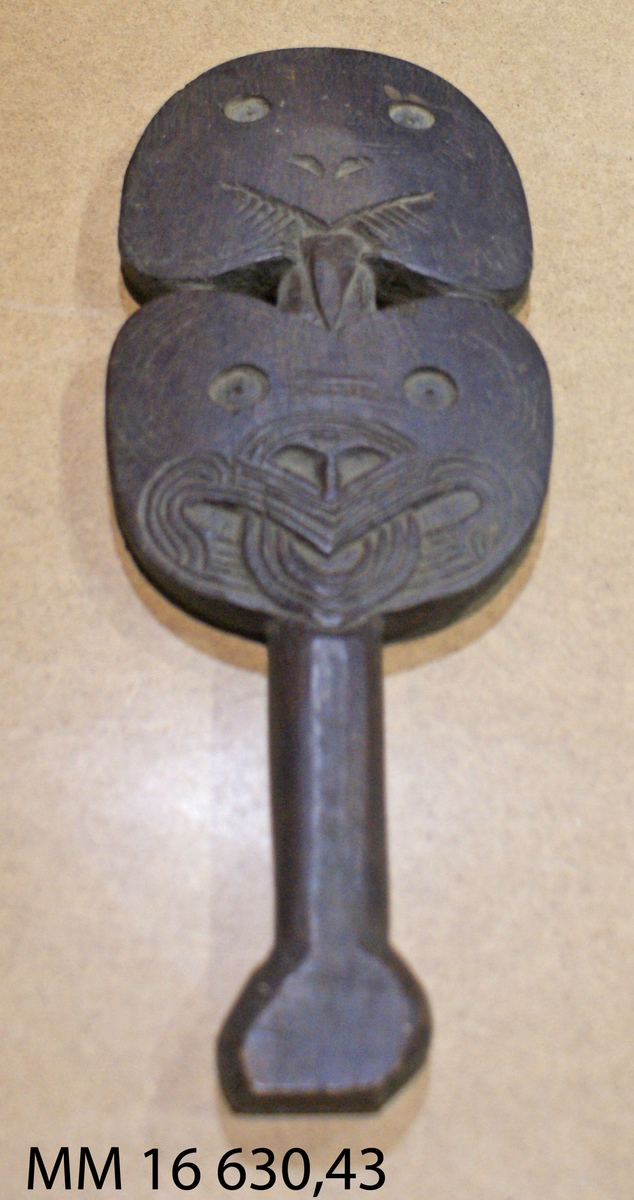 Fiolformat huvud med påbörjade inristningar - maori - tatuering. Kort skaft avslutas med en bredare knapp.