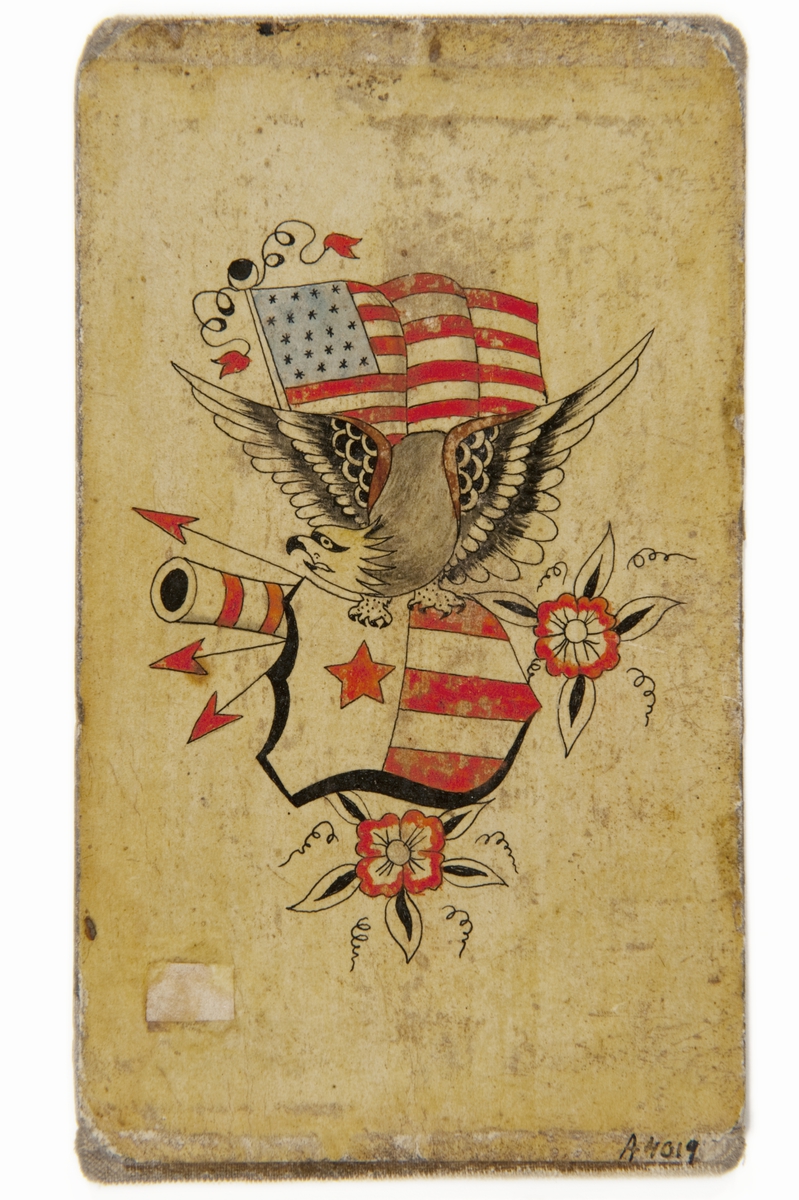 Tatueringsförlaga. En örn med en amerikansk sköld i klorna framför en amerikansk flagga. I bakgrunden ett kanonrör, tre pilar och två röda blommor.
