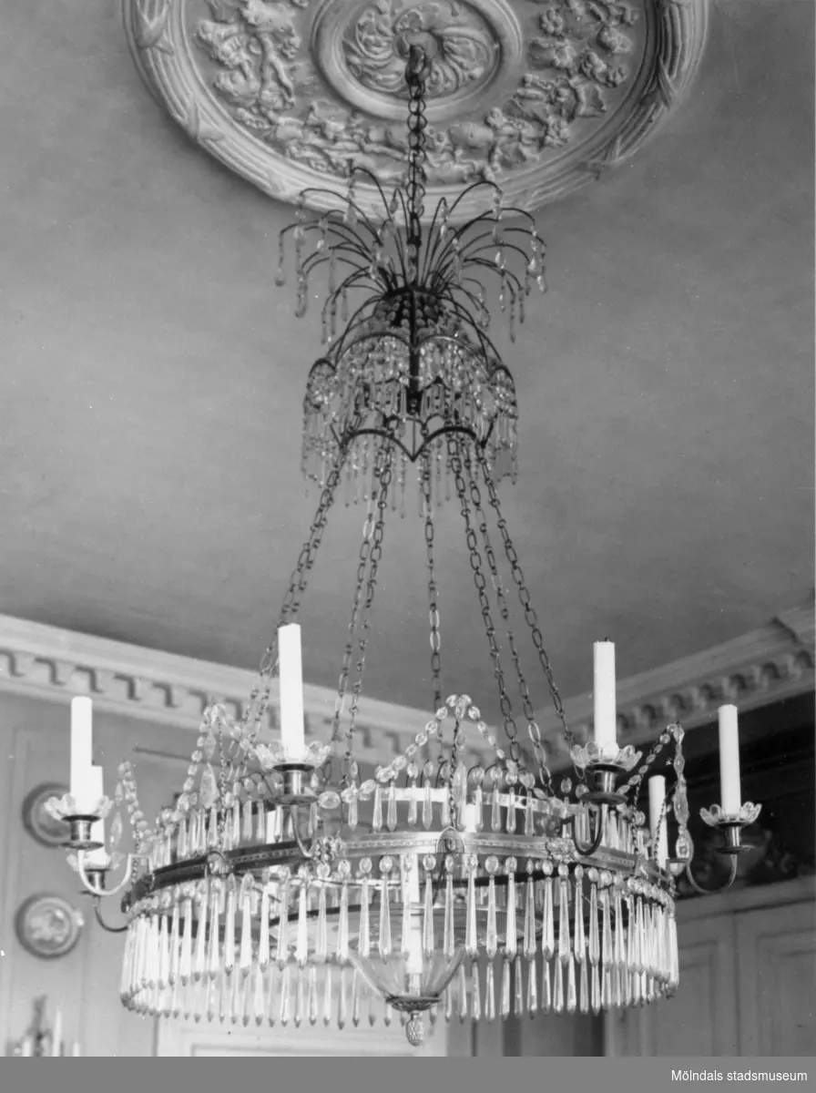 Takkrona med slipade kristallprismor och plats för ljus. Carl Sparre gjorde denna 1909. Matsalen på Gunnebo slott, 1930-tal.