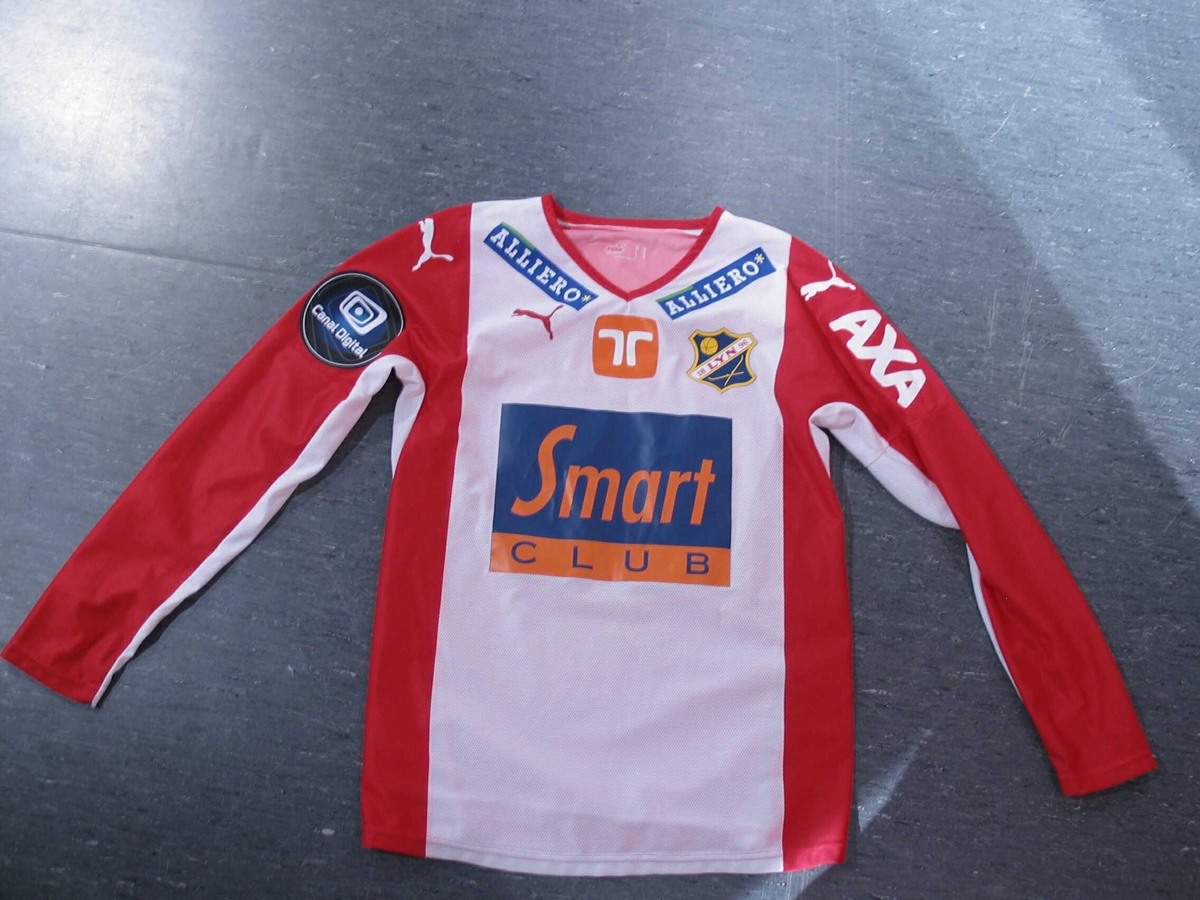 Rød og hvit fotballtrøye med reklame for Atle Brynestads "Smart Club". 