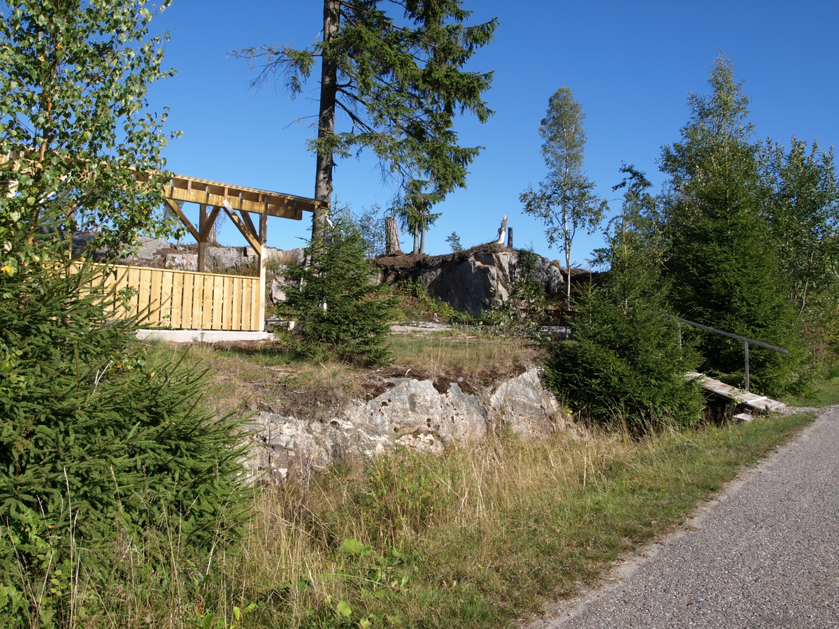 Fra gangveien ved siden av vei 128 går stien til rasteplassen ved Myråsberget. Da plassen var liggeslette, var det skog på berget bak den og på andre siden veien. Foto: Bodil Andersson, Østfoldmuseene/Halden historiske Samlinger.