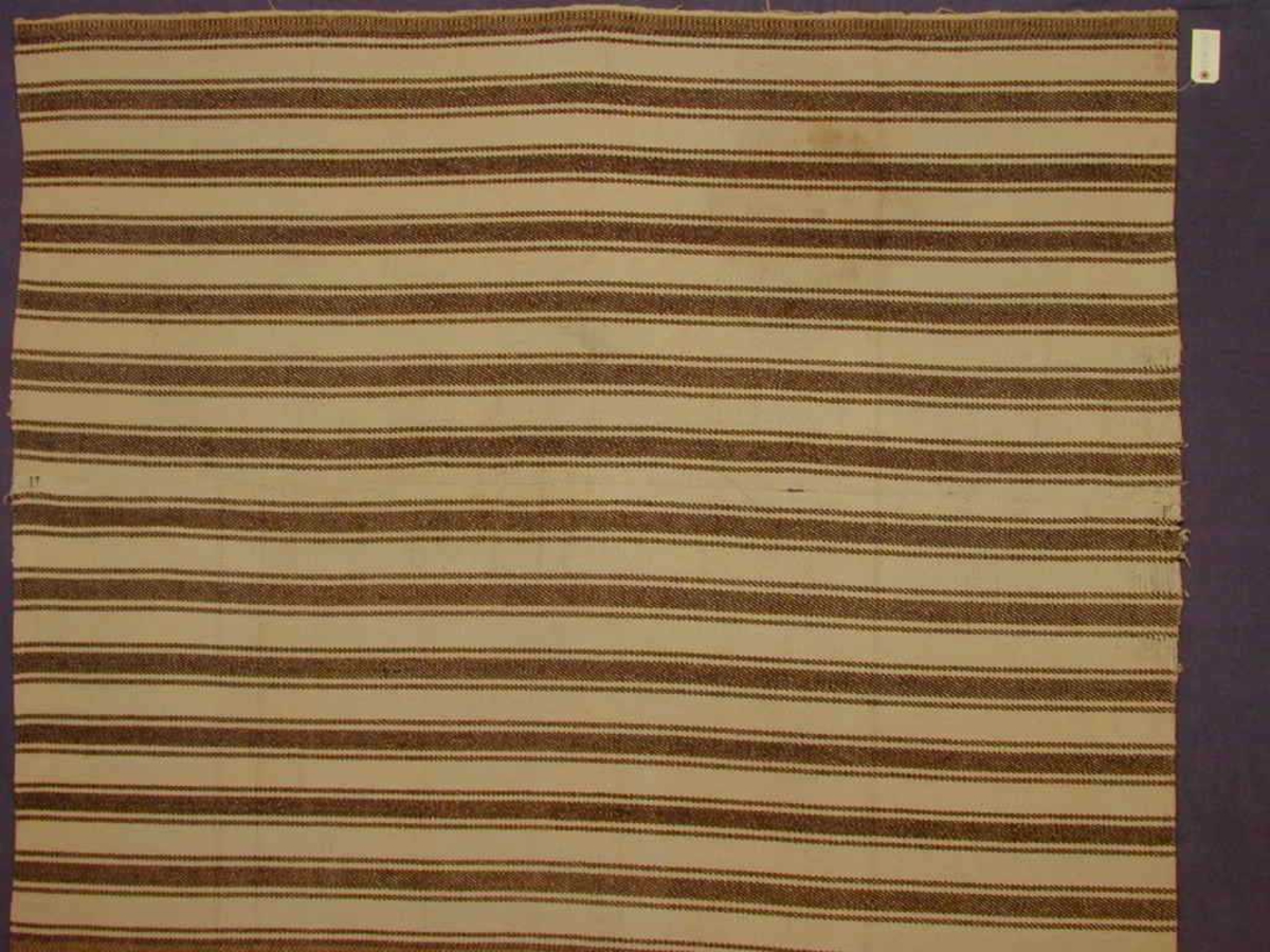 Mellombrune striper i reningsretning over heile teppet