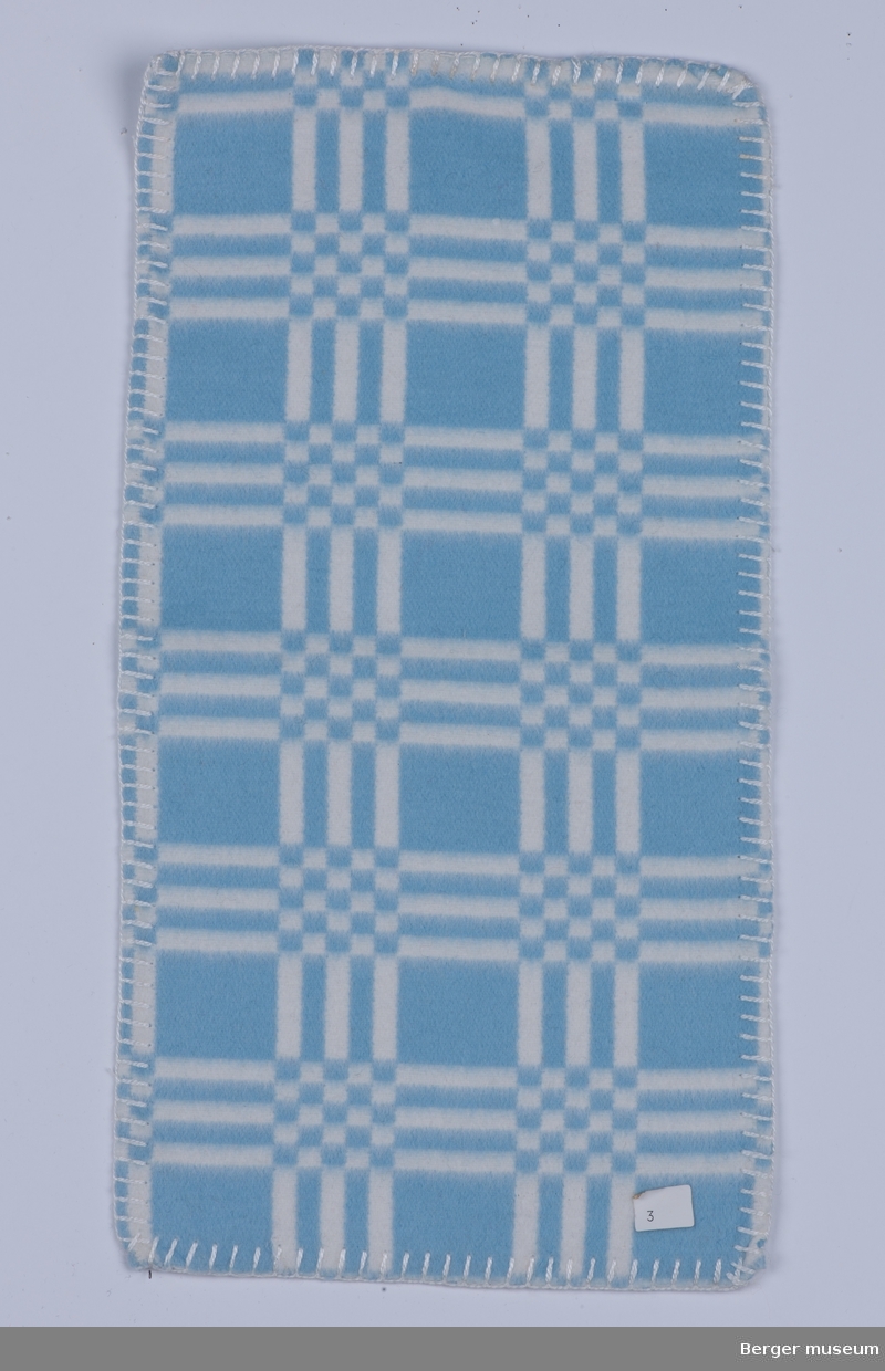 Flanellsteppe. Barnepledd
1 prøve
Stripete med sjakkrutet mønster der stripene møtes.
Dette mønsteret fantes antagelig også i gul og hvit i tillegg til rosa og hvit.