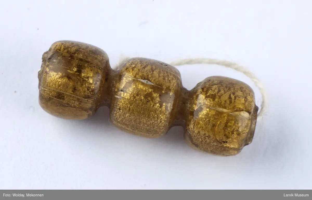 Form: tredelt, gylden glassperle
