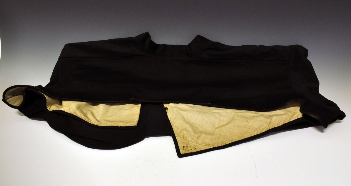 Fra protokoll:Består av:
D: Trøye/jakke  (Slengetrøye) av svart klæde med ei einskild stikka bylgjeline paa kvar erm. Lereftsfôra.