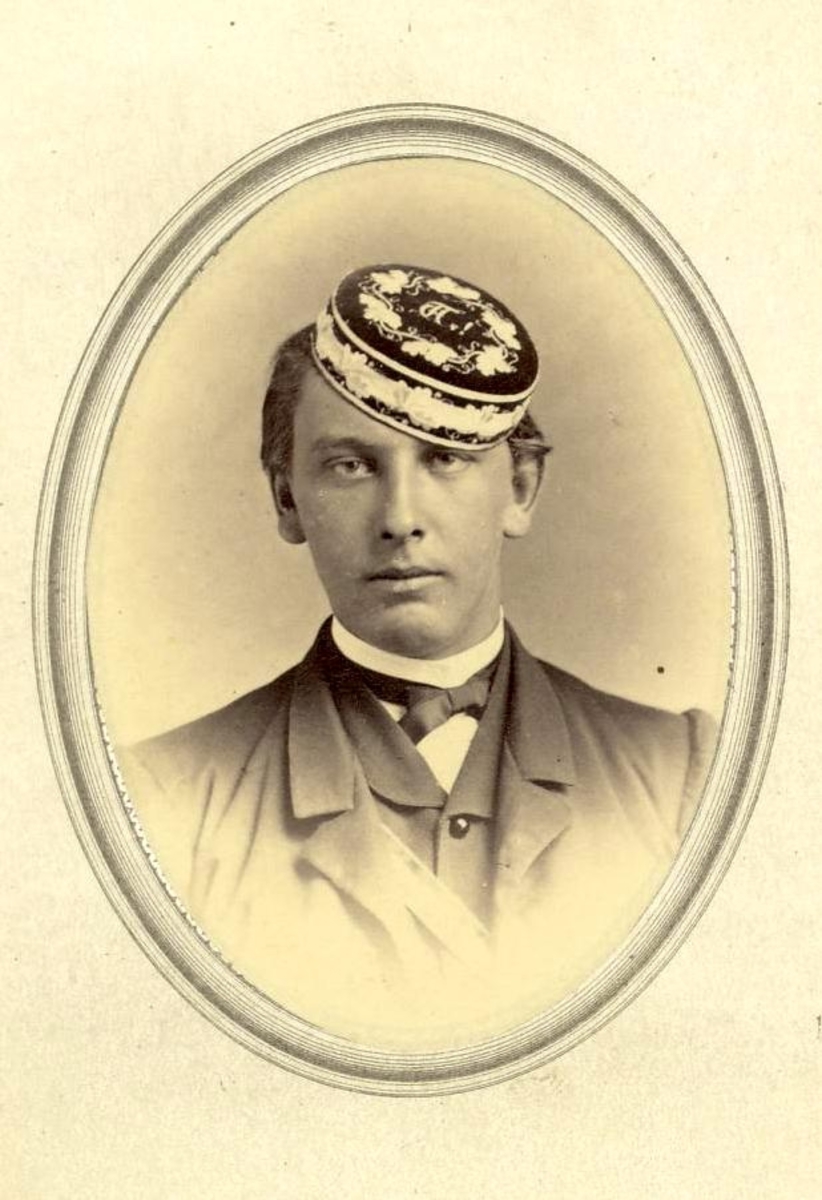 Ovalt portrett av ung mann med dekorert rund lue