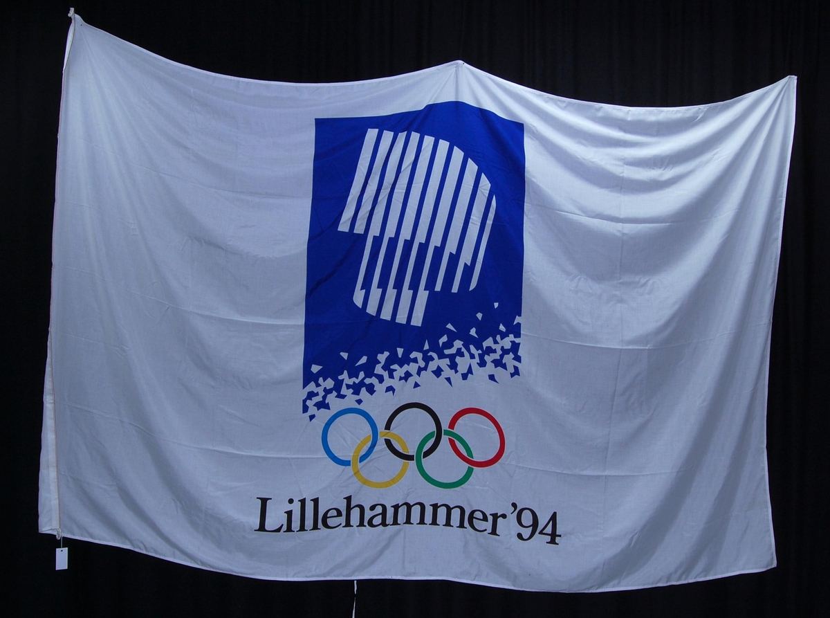 Hvitt banner med flerfarget logo for de olympiske vinterleker på Lillehammer i 1994. 