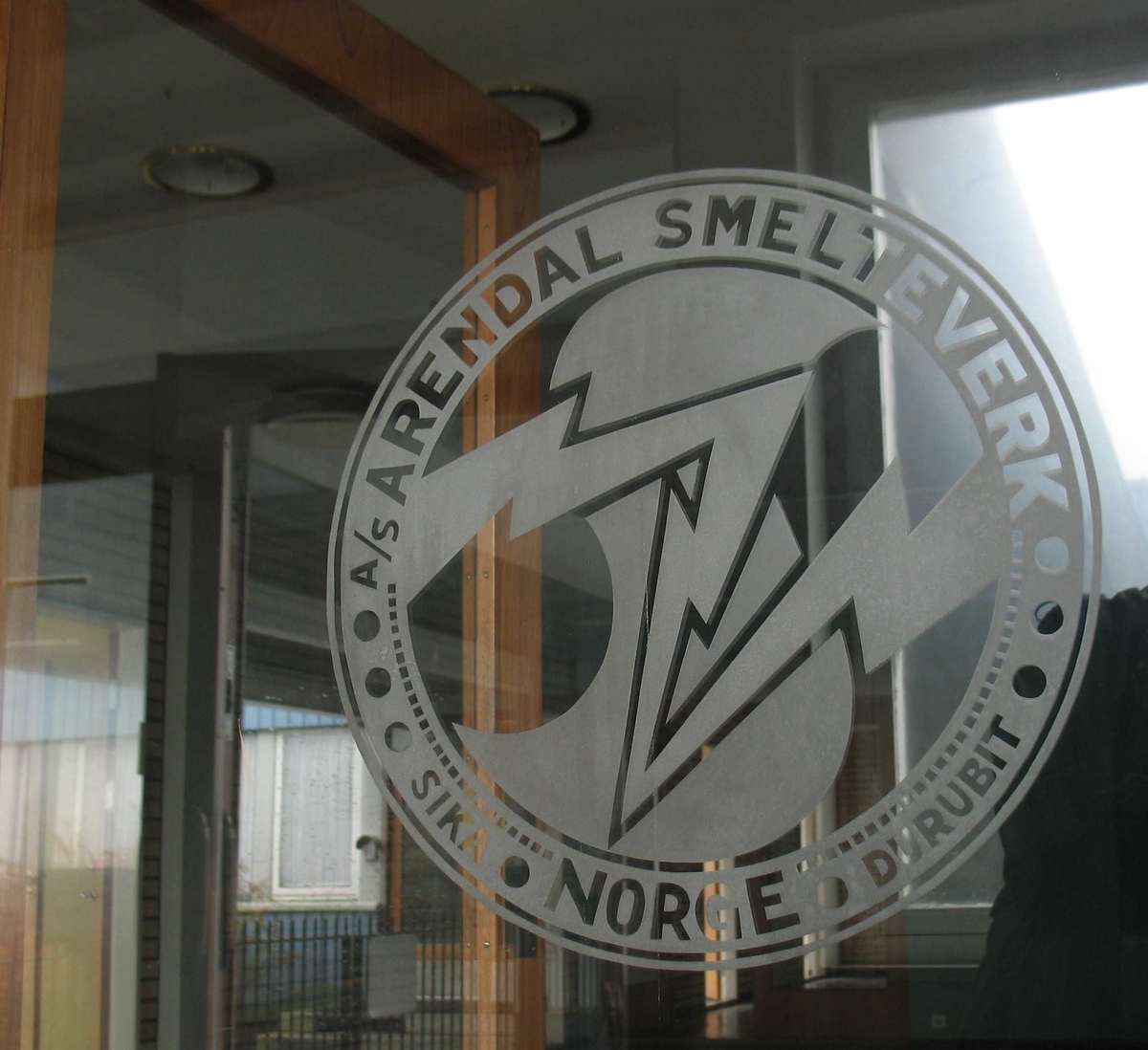 Arendal Smelteverk, kontorbygningen. Dør med innslipt logo. 