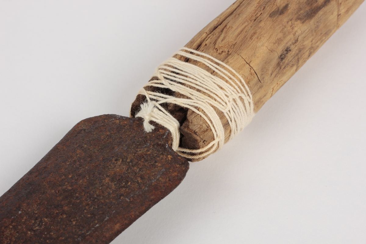 Redskap som brukes for å fjerne bark på hogst. To skaft med skjærebladet mellom. En hvit hyssing/ tråd er surret rundt det ene skaftet.