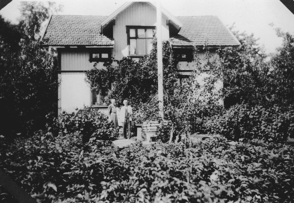 Helga og Herman Karlsen i hagen foran Sætre.