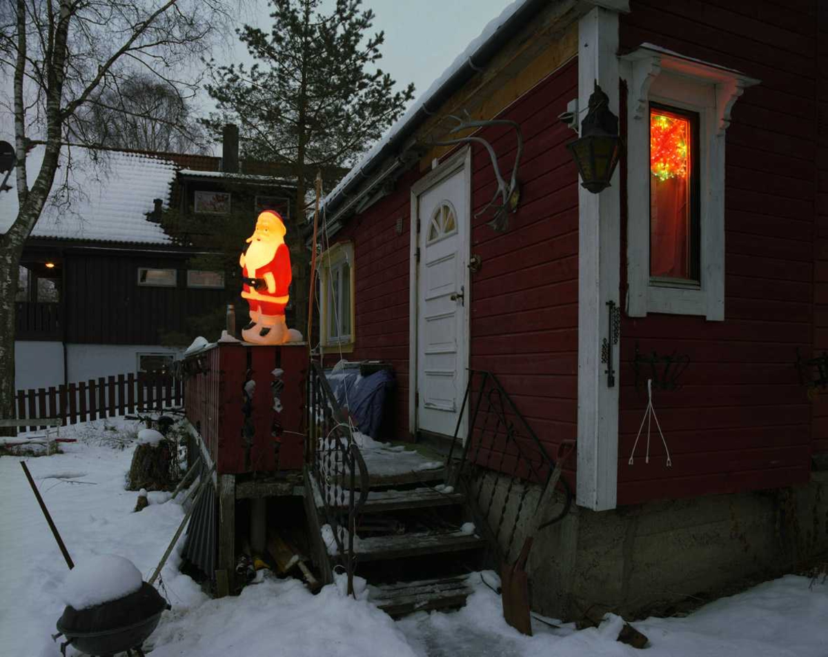 Julebelysning

Lysende julenisse ved inngangsparti og flerfarget stjernedekorasjon i vindu.