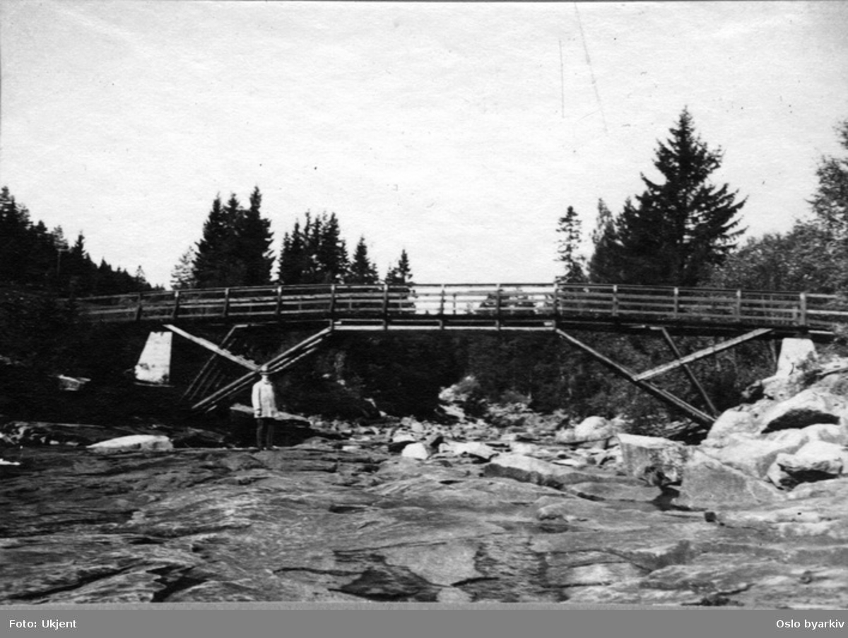 Gangbro i tømmer / Anleggsbru over elv.