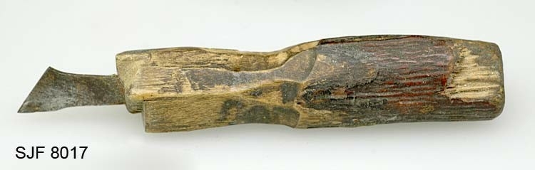 Graverjern, brukt av knivmakeren Ole Jacobsen Vestby (1875-1954) til å gravere mønster både på slirer og skaft. Skaftet på dette redskapet er løagd av en 7,2 centimeter lang pinne, der den fremre enden (mot graverstålet) er spikket noe konkavt med tollekniv. Den bakre enden har et hull som kan indikere at dette skaftet tidligere har vært skjeftet med et annet stål i motsatt ende av det nåværende. Det nåværende stålet er 1 millimeter tjukt og tiltar i bredde mot ytterenden, hvor det er ei skrå, 1,2 centimeter lang endeflate som er spiss i den fremre enden. I opprinnelig registreringstekst heter det at dette redskapet «særlig ble brukt til laging av drageornamenter, som var Ole J. Vestbys spesialitet».