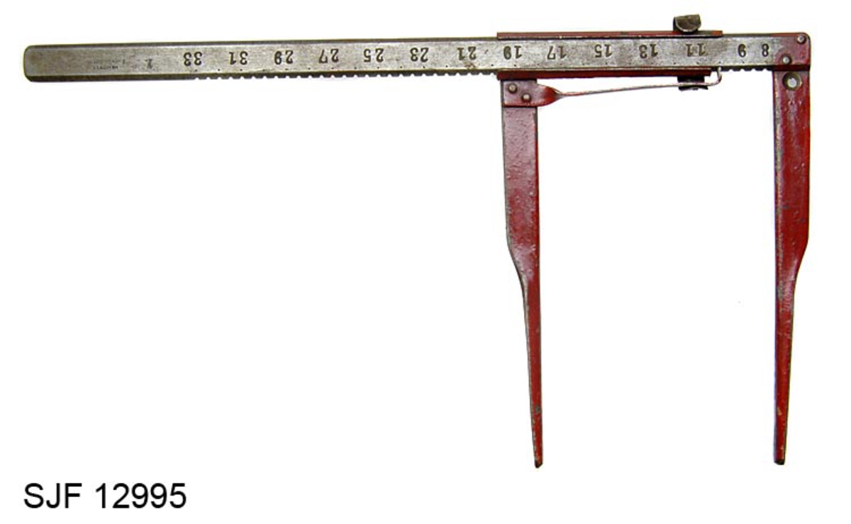 Klave til undersøkelse av diametermål på tømmer. Klaven ble brukt av hoggere som registrerte diametermålet i sine akkordrapporter. Klaven har F-form. Denbestår av en målekase og to målearmer. Klaven har en centimeterskala fra som gjør det mulig å måle diametere mellom 8 til 33 centimeter, med intervaller på 2 centimeter. Klaven har en fast og en bevegelig målearm. Den bevegelige målearmen kan flyttes langs en "linjal". Denne armen er klinket fast til et jernbeslag som delvis omslutter "linjalen". Målearmen skyves langs måleaksen inntil den stopper mot stokkens ytterkanter.  Den bevegelige målearmen har påklinket ei stålfjær. Det er innfilt spor, hakk, for stålfjæra i målekasen slik at den bevegelige målearmen holdes fast under avlesning. Dette sikrer at avlesningen stabil. Den faste målearmen er naglet fast til linjalen. Det er stanset ut et hull i den faste målearmen. Her kan det festes en opphengsring, men denne komponenten mangler på dette eksemplaret.