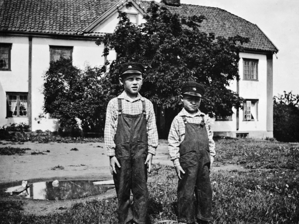 Foran hovedbygningen på Vien, Helgøya. Ole Reinert Narmo f.1925 og Arne Mauritz Narmo f. 1928.