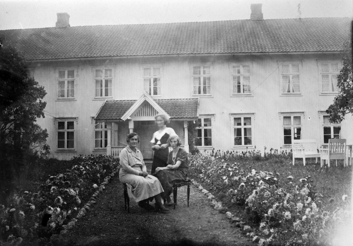Eksteriør, hovedbygningen på Fossum, Nes, Hedmark. 3 damer ved blomster bed. Anna Storlien f.1875 med sine døtre Magdalena Sterud (1902-1994), Asbjørg Haram f.1909.