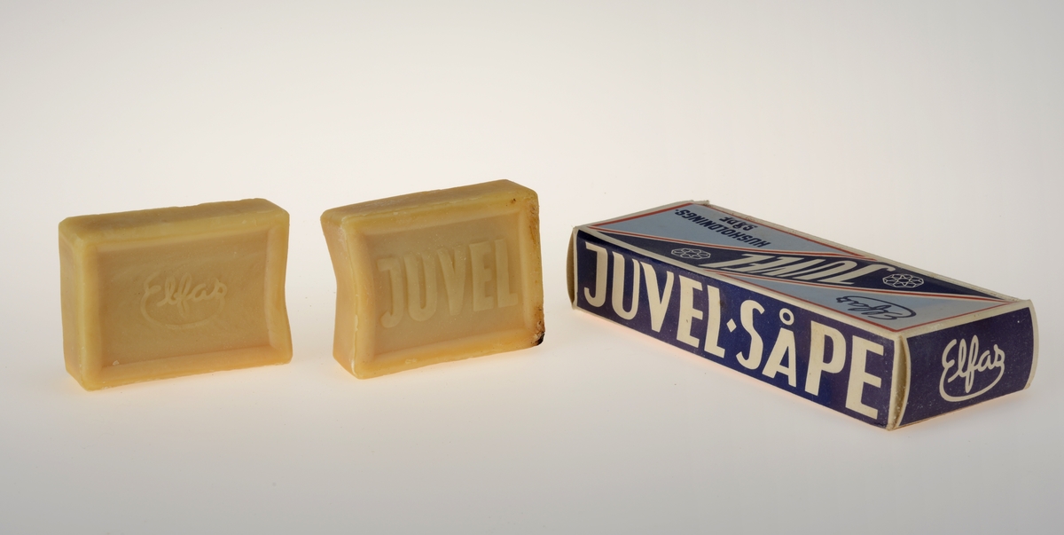 Rektangulær pappeske med to såpestykker av merket Juvel. Bruksanvisning på baksiden med illustrasjoner, Juvel kan brukes til oppvask og husvask, storvask, kulørt tøy, ull og silke.