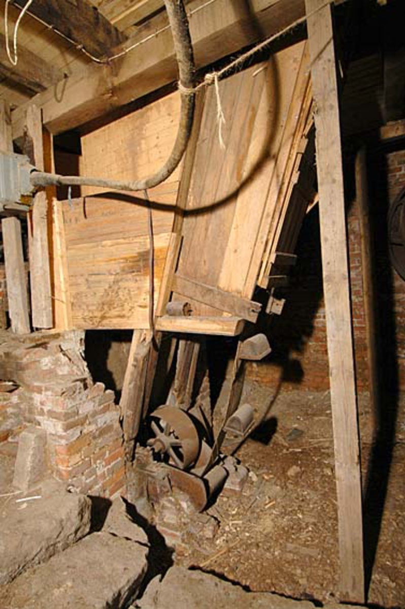 Fliskjelleren er under hoggeriet. Dette er ingen arbeidsplass for produksjonen i Klevfos. Her ses nedre ende av koppelevator, dens kretsløp løftet flis fra hoggeriet og opp til Flisloftet. Fundamentert i tegl.  Løten. Ådalsbruk.