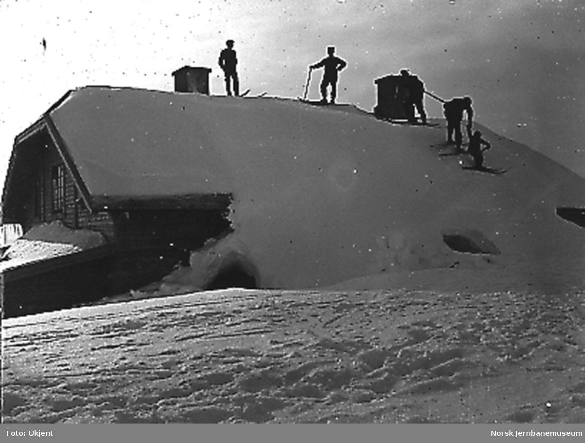 Fem mann på ski på taket av Fagernut vokterbolig
