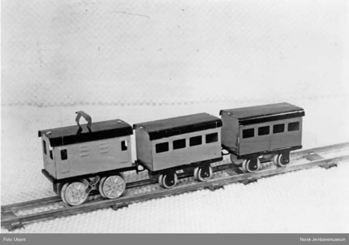 Leke : modell av elektrisk lokomotiv med tre vogner og stasjon