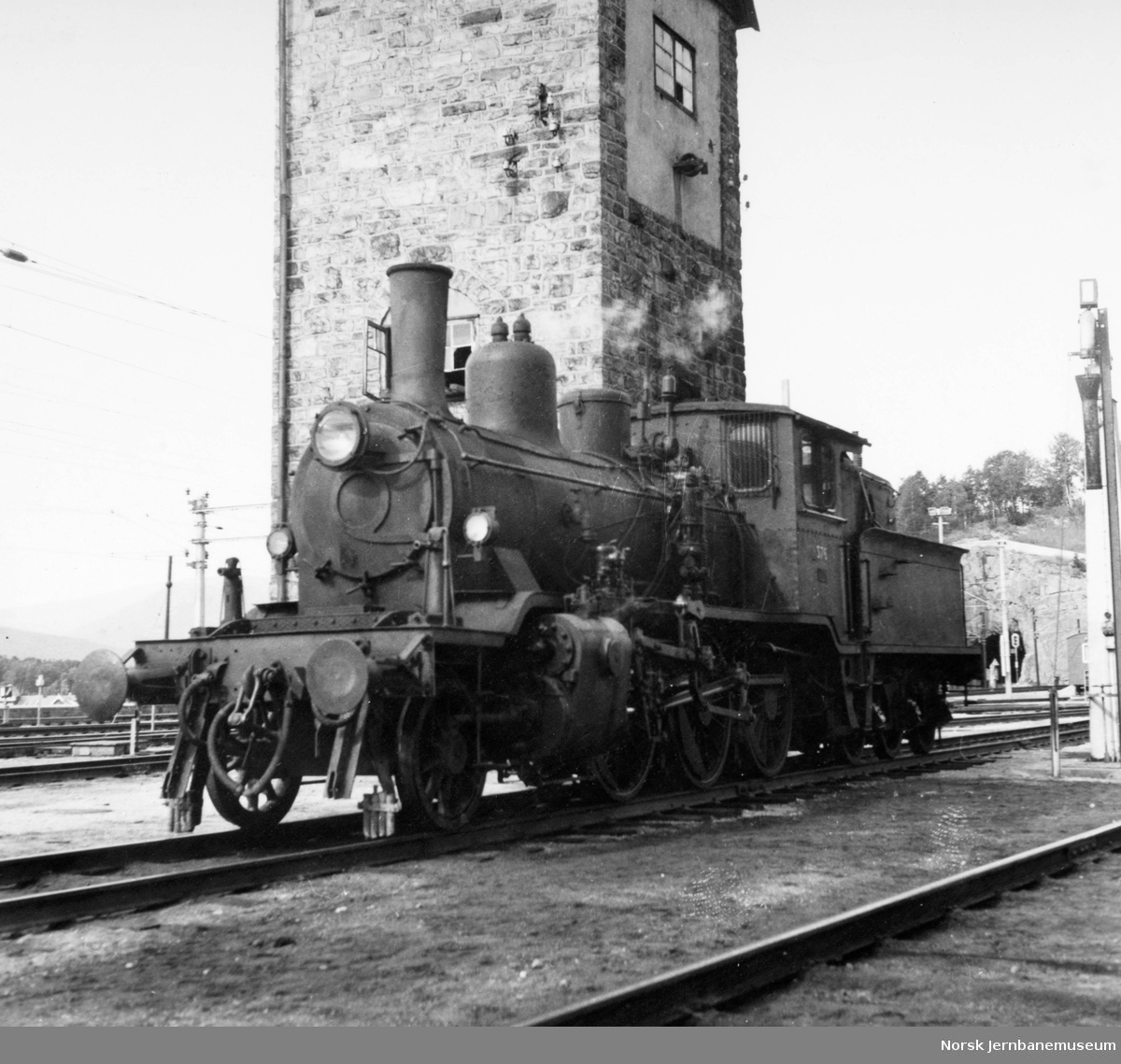 Damplokomotiv type 21c nr. 376 foran vanntårnet på Dombås stasjon