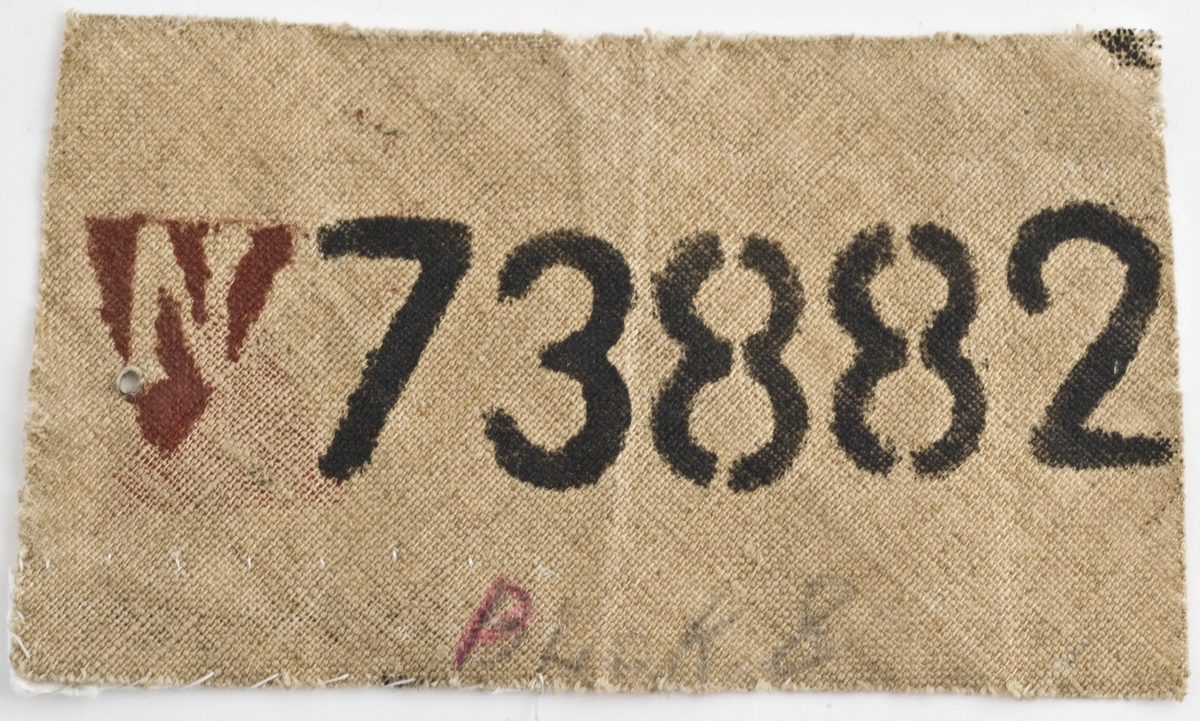Fangeskilt i tekstil med fangenummer.