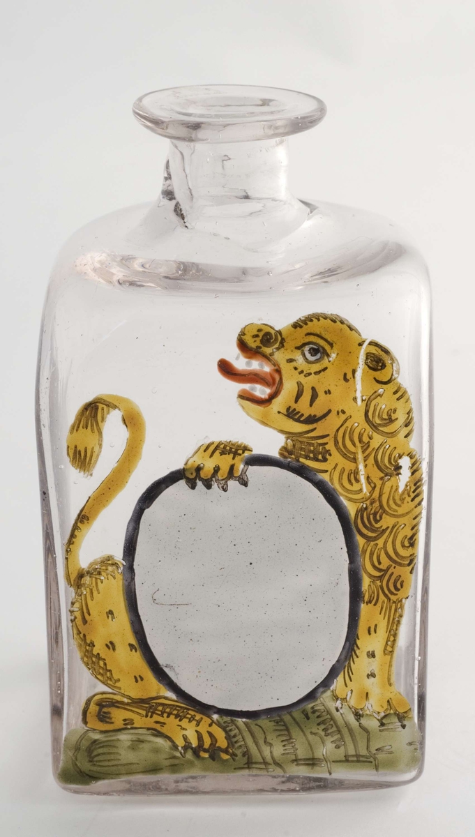 Firkantet glass uten propp, trang hals. Påmalt ovalt, hvitt etikettfelt. 
Dekormotiv: Løve som holder etiketten.