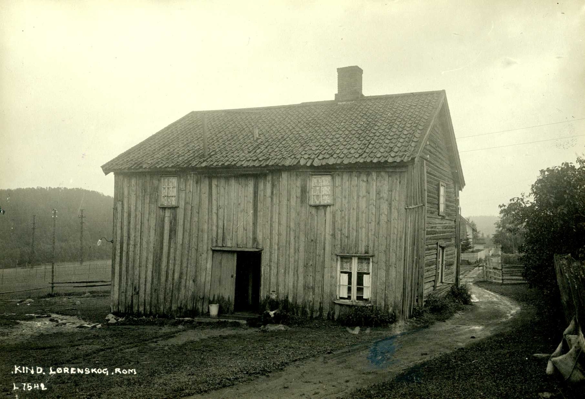 Kind, Lørenskog, Nedre Romerike, Akershus. Gammelt våningshus, vei passerer langs husveggen.