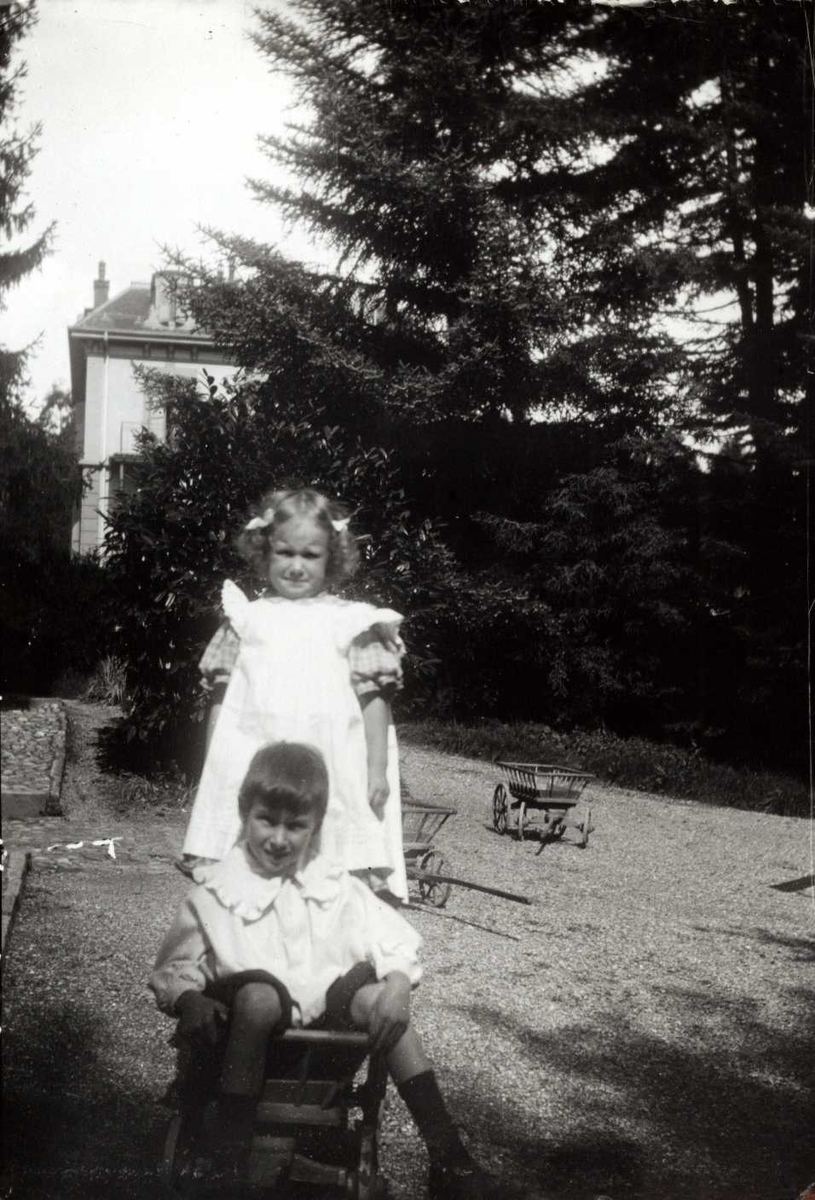 Dobbeltportrett, Sveits. Jente og gutt  i lek med trevogner.
Ant. fra serie fotografert av kammerherre Fredrik Emil Faye (1844-1903), Dal gård, Ullensaker.