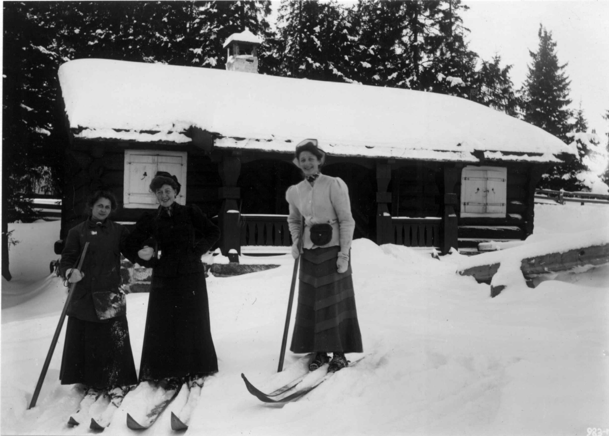 Frognerseteren, Oslo. 1908-1910. Vintermotiv. Kvinnelige skiløpere. En av dem heter frk. Tønder. Hytte i bakgrunnen.  