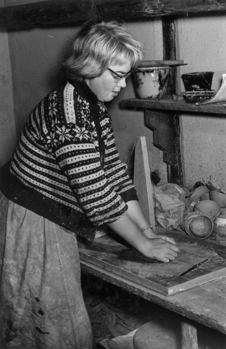 Kvinnelig keramiker i arbeid på pottemakeriet.